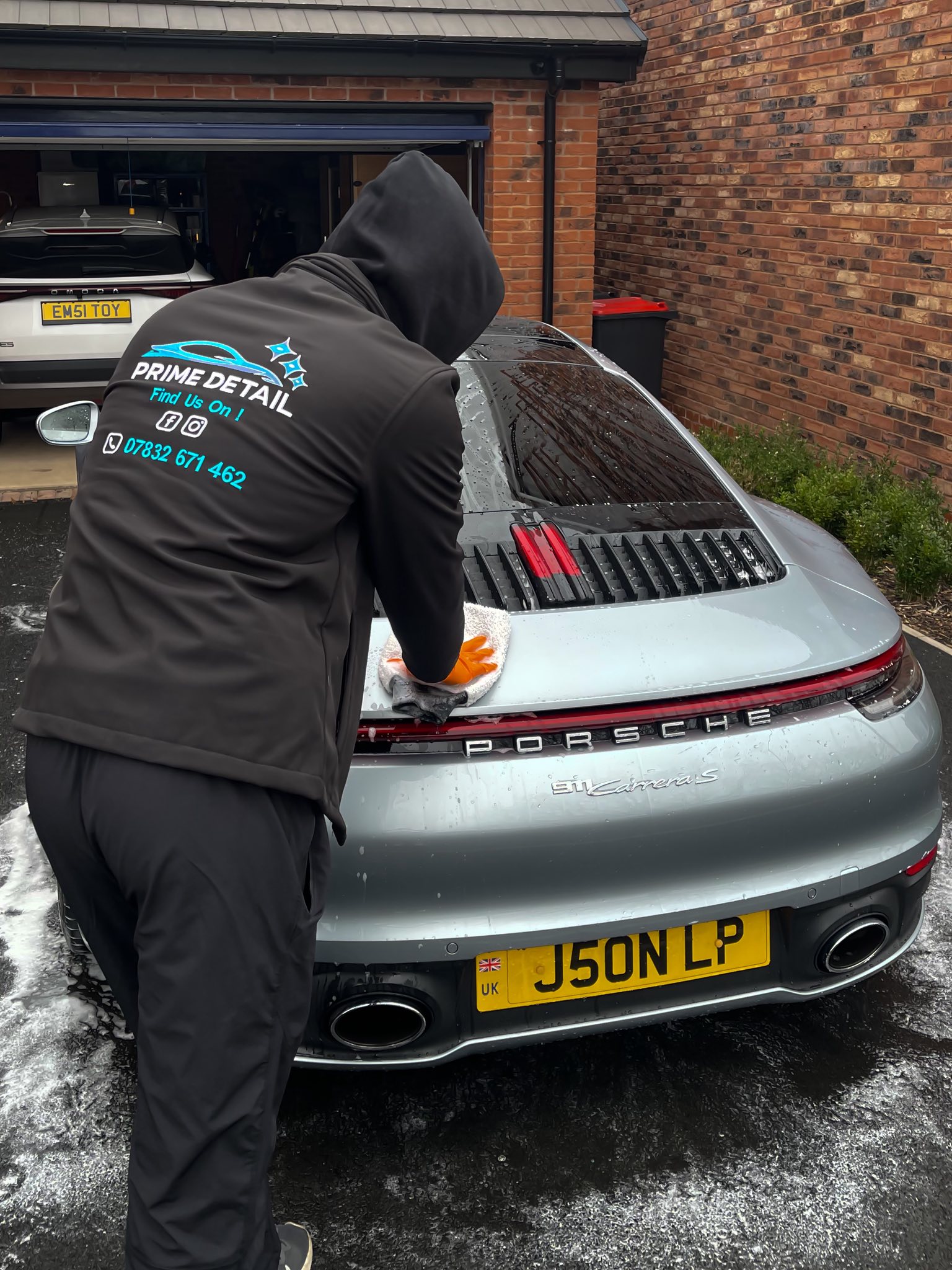 PrimeDetail technician detailing a Porsche 911 Carrera S